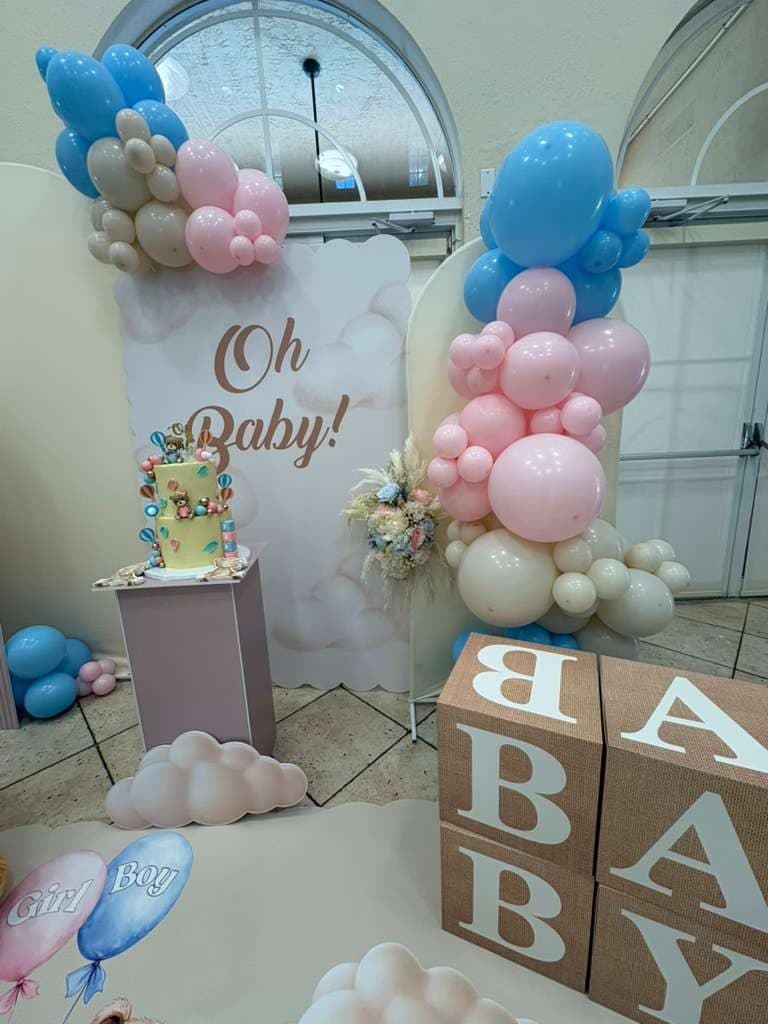 Pink and blue 'Oh Baby' gender reveal cake table with balloon column and BABY blocks